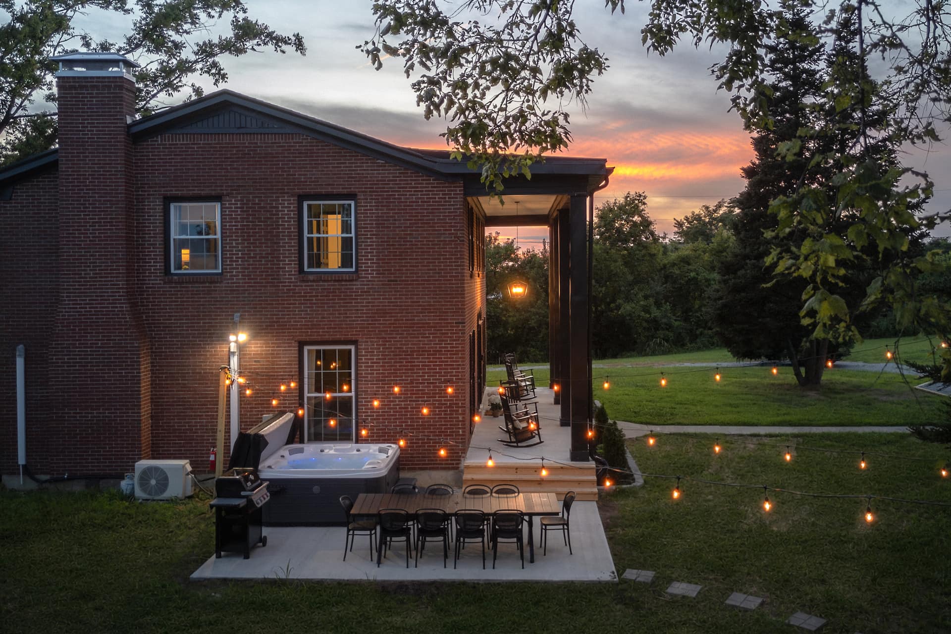 The estate patio lit by string lights at sunset